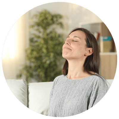 Une femme avec les yeux fermés faisant une respiration profonde et consciente, un exercice de yoga des émotions.